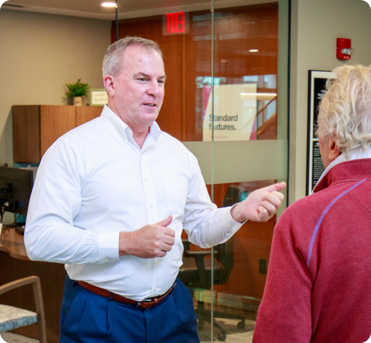 Bank employee speaking with a customer inside a branch lobby.