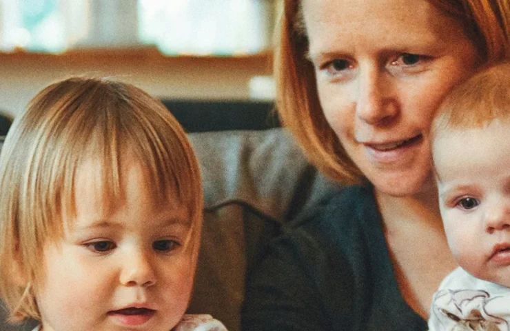 Mother sits on couch with her two children