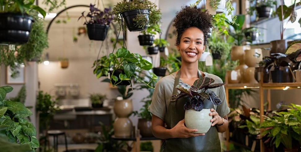 Smiling female business owner in her plant shop.