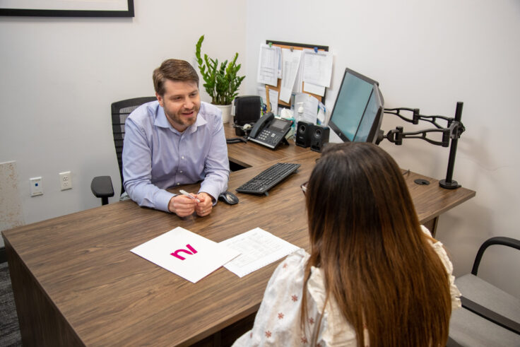 New Valley Bank employee meeting with a customer in an office setting to discuss financial services